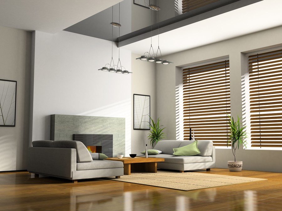 Open floor plan living room with a couch, coffee table, and two large windows featuring lowered blinds. 